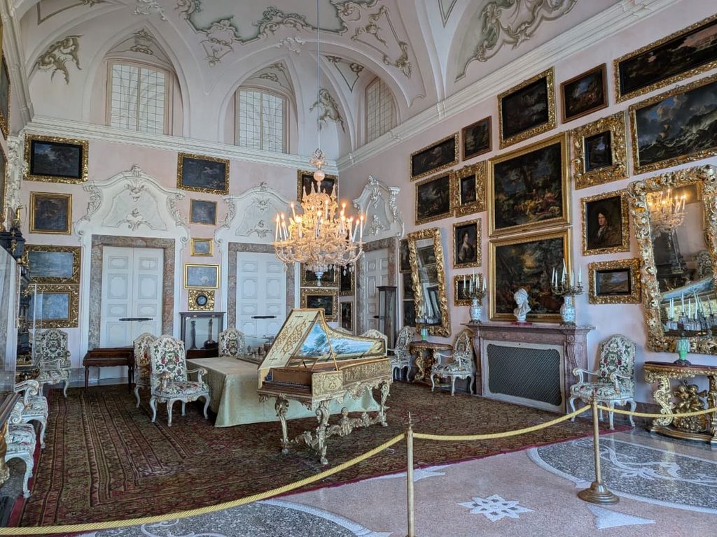 Inside Palazzo Borromeo on Isola Bella, gilded paintings, crystal chandeliers, antique furniture and ornate stucco reveal the lavish interiors that make exploring the Borromean Islands on Lake Maggiore so memorable.
