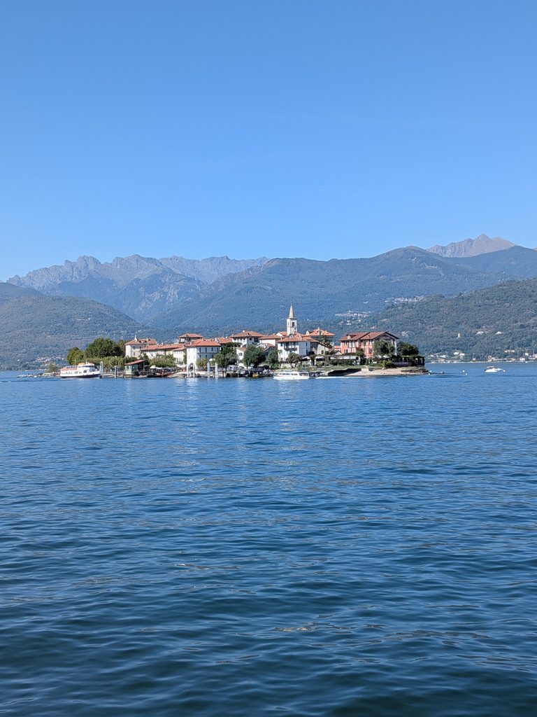 Isola dei Pescatori sits on Lake Maggiore beneath the surrounding Alpine mountains, with its compact village and church.