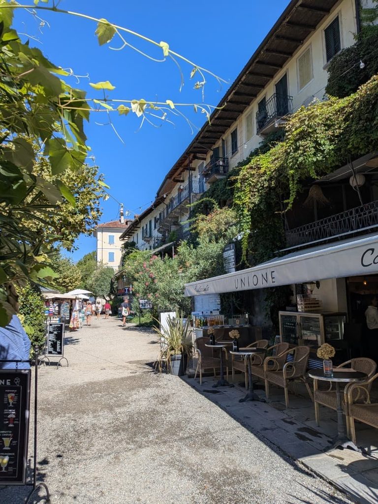 Cafés and ivy-covered houses line a sunny pedestrian street on Isola Superiore.
